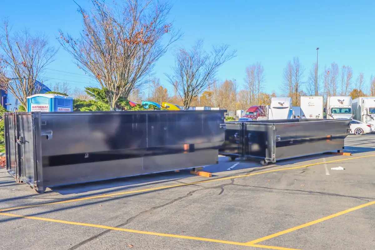 Professional dumpster rental service with roll-off container on residential driveway in Bayonne